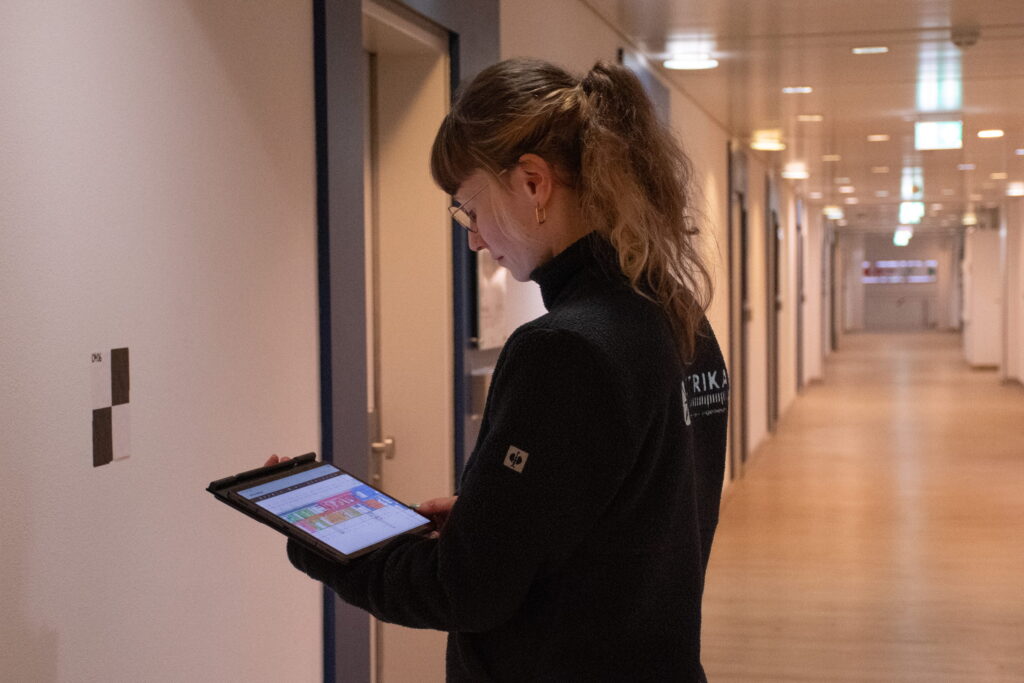 Attributerfassung während der Begehung: die Eingabemaske auf dem Tablet, der Raum dahinter.