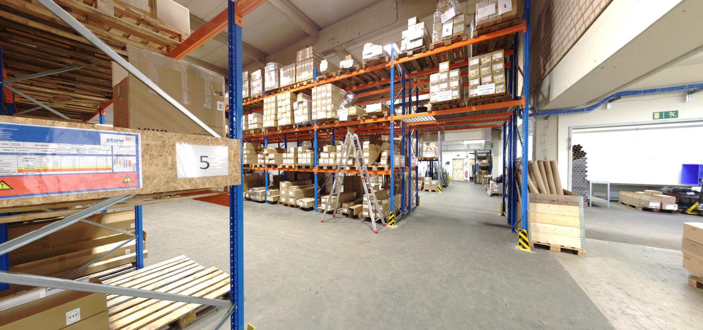 Blick durch eine Lagerhalle mit Palettenregalen, aufgenommen aus dem virtuellen Rundgang.
