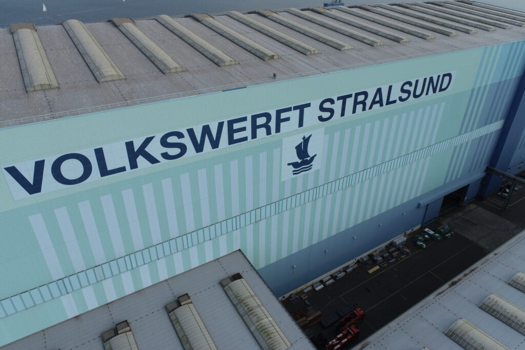 werft-fassade-drohnenaufnahme Drohnenaufnahme einer Werfthalle: Längsfassade mit dem Schriftzug Volkswerft Stralsund, darüber die Reihe der Dachlaternen.